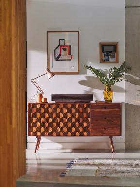 Sideboard with Naim's sound player placed on top and framed image on wall.