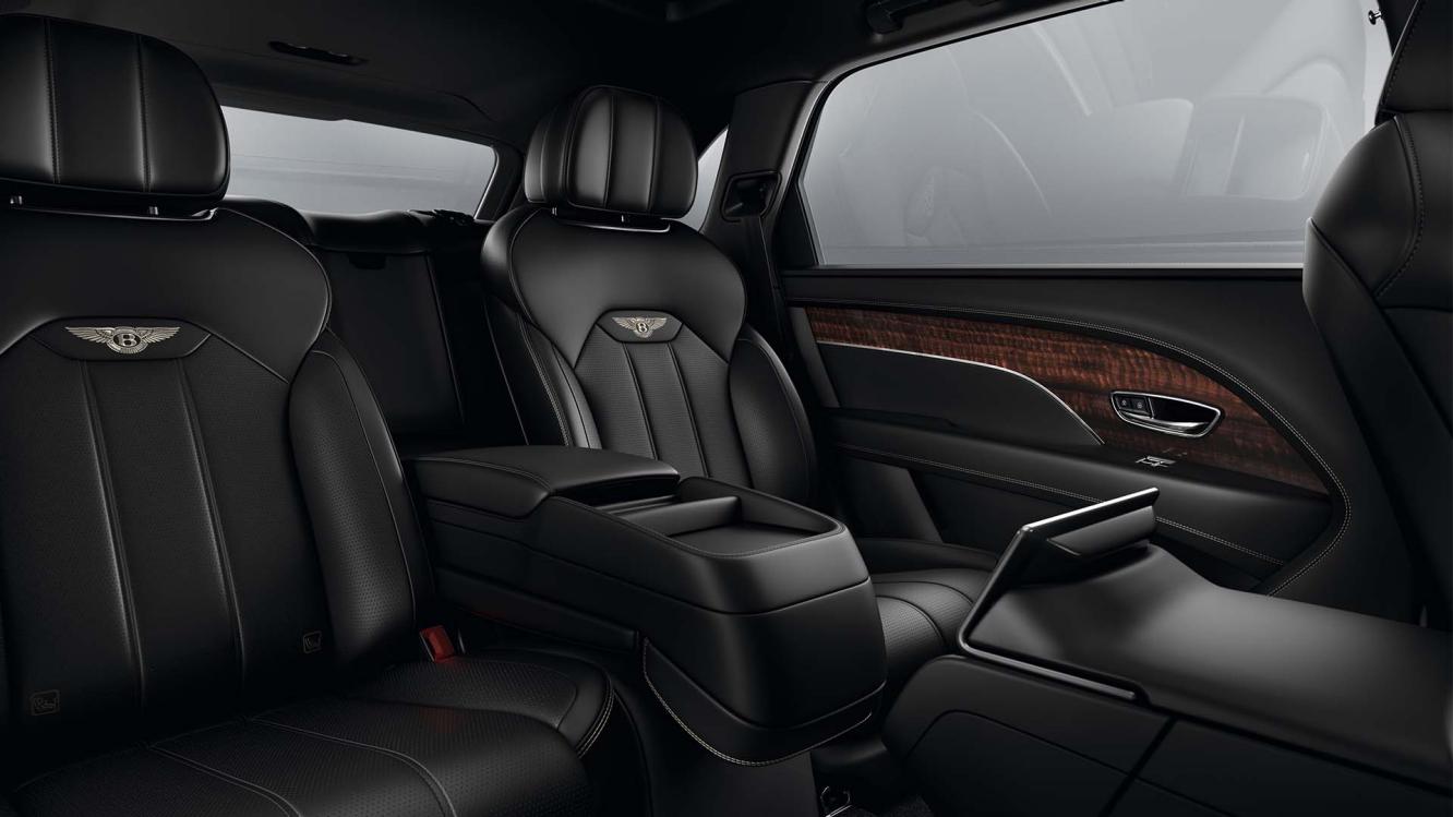 Rear passenger seat view of Bentley Bentayga EWB featuring Beluga hide and contrast stitching of Bentley emblem in Linen.