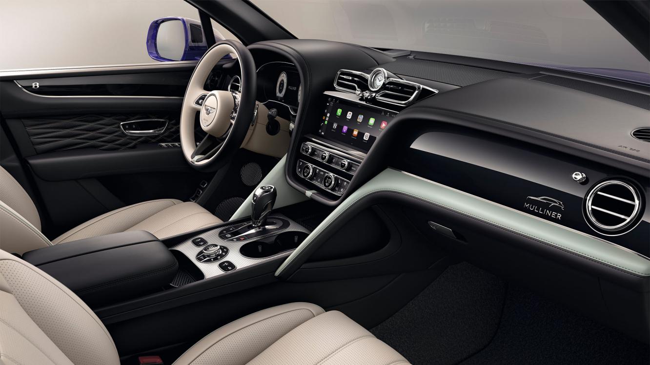View over looking driver's seat of Bentley Bentayga EWB Mulliner, featuring Grand Black veneer with Mulliner Overlays and Aluminium Console.