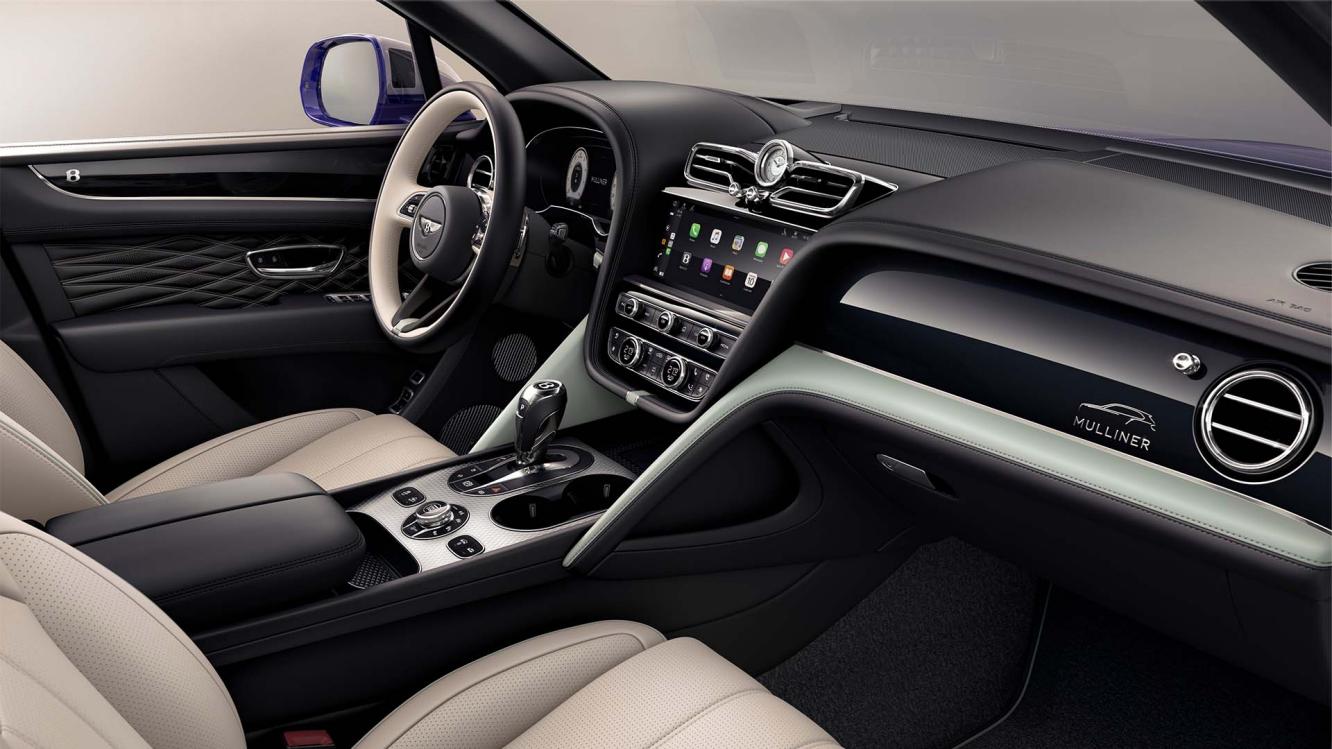 "View over looking driver's seat of Bentley Bentayga EWB Mulliner, featuring Grand Black veneer with Mulliner Overlays and Aluminium Console. "