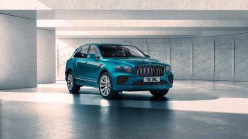 Bentley Bentayga Azure, front three - quarter view with Topaz blue exterior featuring matrix grille behind fluted chrome vents.