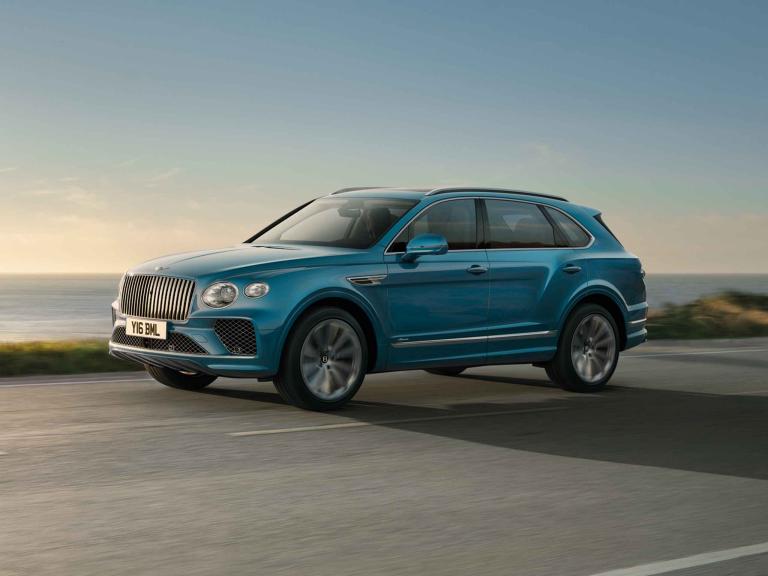 Bentley Bentayga Azure side view in Topaz blue / Kingfisher- by Mulliner colour, featuring 22 inch Painted and Diamond Turned Wheel, driving along sea side.