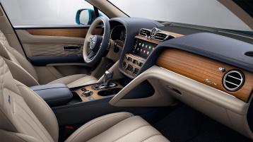 View over looking driver's seat of Bentley Bentayga EWB Azure, featuring Grand Black veneer with Mulliner Overlays and Aluminium Console.