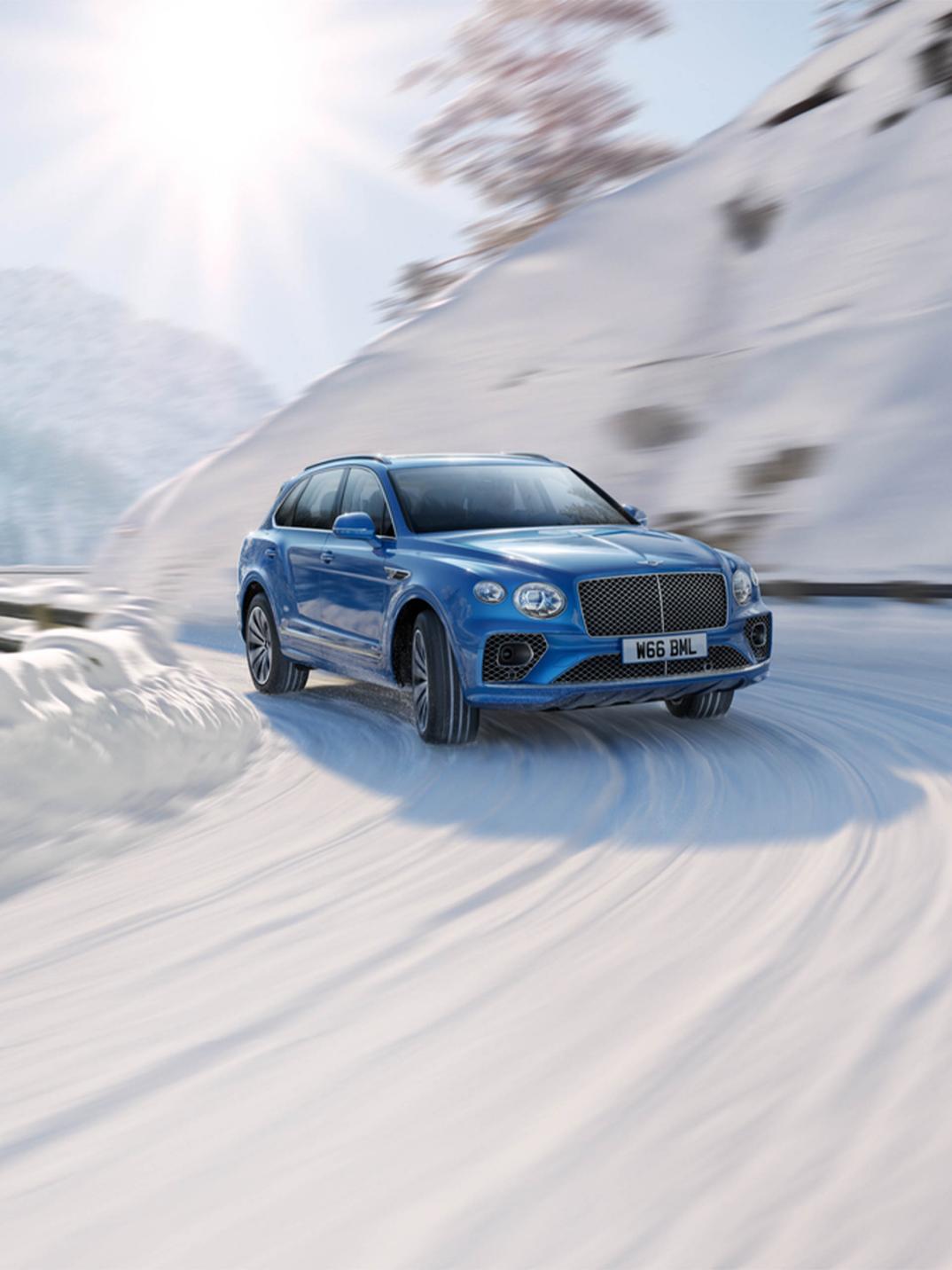 Bentley Bentayga Azure in Kingfisher - by Mulliner colour, effortlessly driving along snowy road featuring 2i inch Five-Twin Spoke Wheel - Painted.