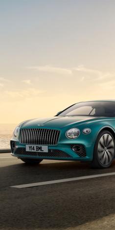 Front end of Bentley Continental GT Azure in Topaz Blue colour featuring Black Gloss matrix grille with chrome surround and vertical fluted vanes.