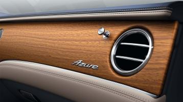 Passenger side view of Bentley Continental GT Azure, featuring Open Pore Koa veneer and Metal bulls-eye vents with organ stops above Azure fascia badge.