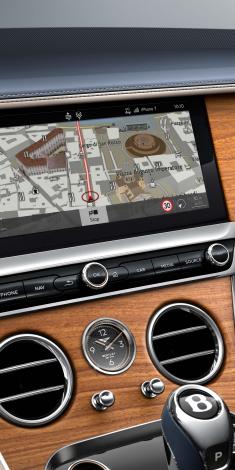 Infotainment system of Bentley Continental GT Azure with 12.3 inch display screen featuring HDD navigation and hard key controls.