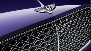 Close up of front end of Bentley Continental GT Mulliner W12 in Tanzanite Purle colour with Black gloss matrix grille with chrome surround.
