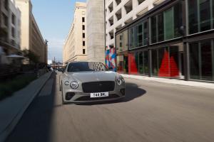 Bentley Continental GT Speed in Orange Flame featuring Dark tint radiator matrix driving along a highway.