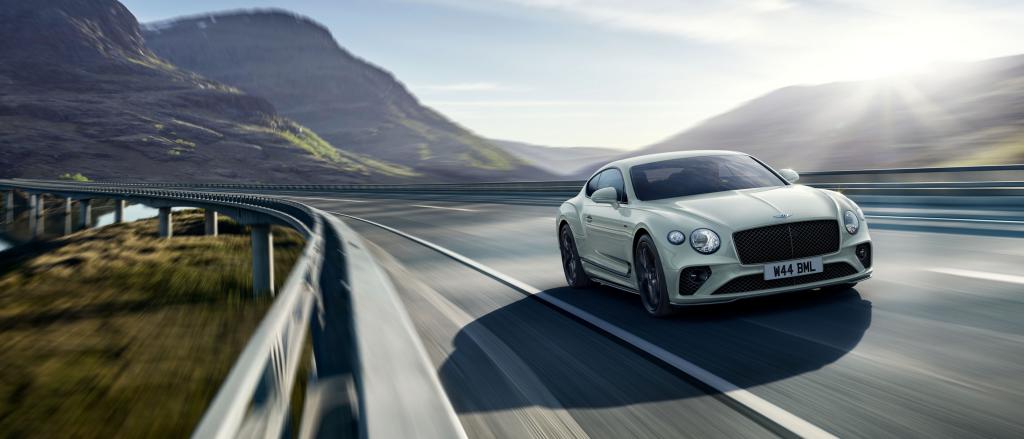 Bentley Continental GT Speed Edition 12 in Arctica (Solid) colour featuring Dark tink radiator matrix and Bentley Wings Badge to bonnet driving along a highway.