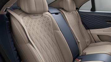 Rear passenger seats of Bentley Flying Spur Azure V8 with Azure emblem in main Portland Hide and Imperial Blue Azure emblem secondary hide featuring 4 seat configuration.