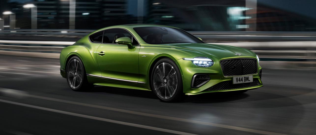 The new Hybrid Bentley Continental GT Speed in Tourmaline Green driving in an urban environment