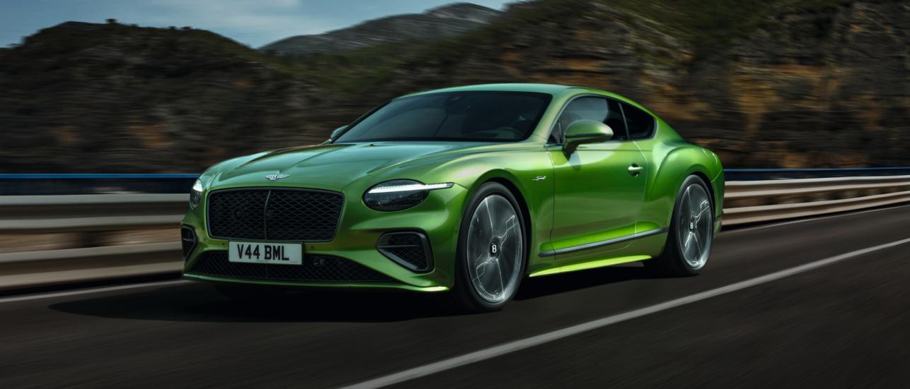The new Hybrid Bentley Continental GT Speed in Tourmaline Green driving in an urban environment