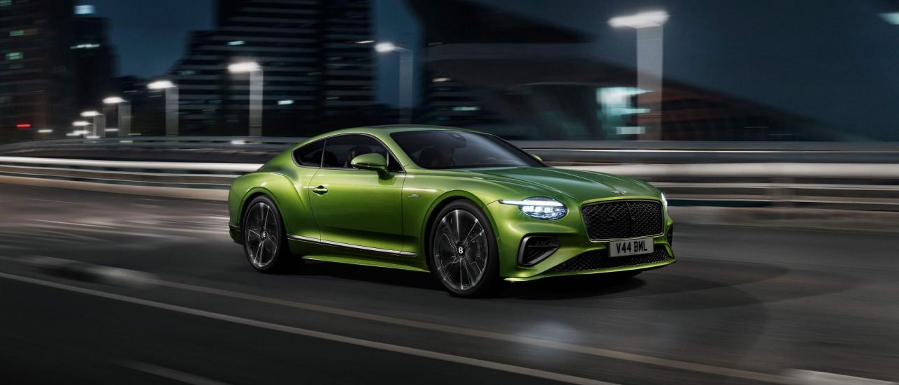 New Continental GT Speed in Tourmaline Green with 21 inch directional Speed wheels driving in an urban environment