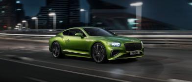New Continental GT Speed in Tourmaline Green with 21 inch directional Speed wheels driving in an urban environment