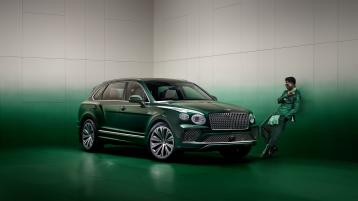 Wisdom Kaye standing next to the front three quarter of the Bentayga Atelier Edition in an Emerald exterior colours with bright chrome accents