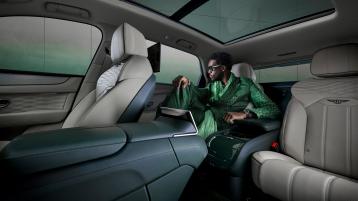 Wisdom Kaye sitting in the rear cabin of the Bentayga Atelier Edition with Portland main hide and Cumbrian Green secondary hide