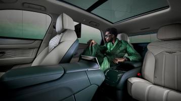 Wisdom Kaye sitting in the rear cabin of the Bentayga Atelier Edition with Portland main hide and Cumbrian Green secondary hide