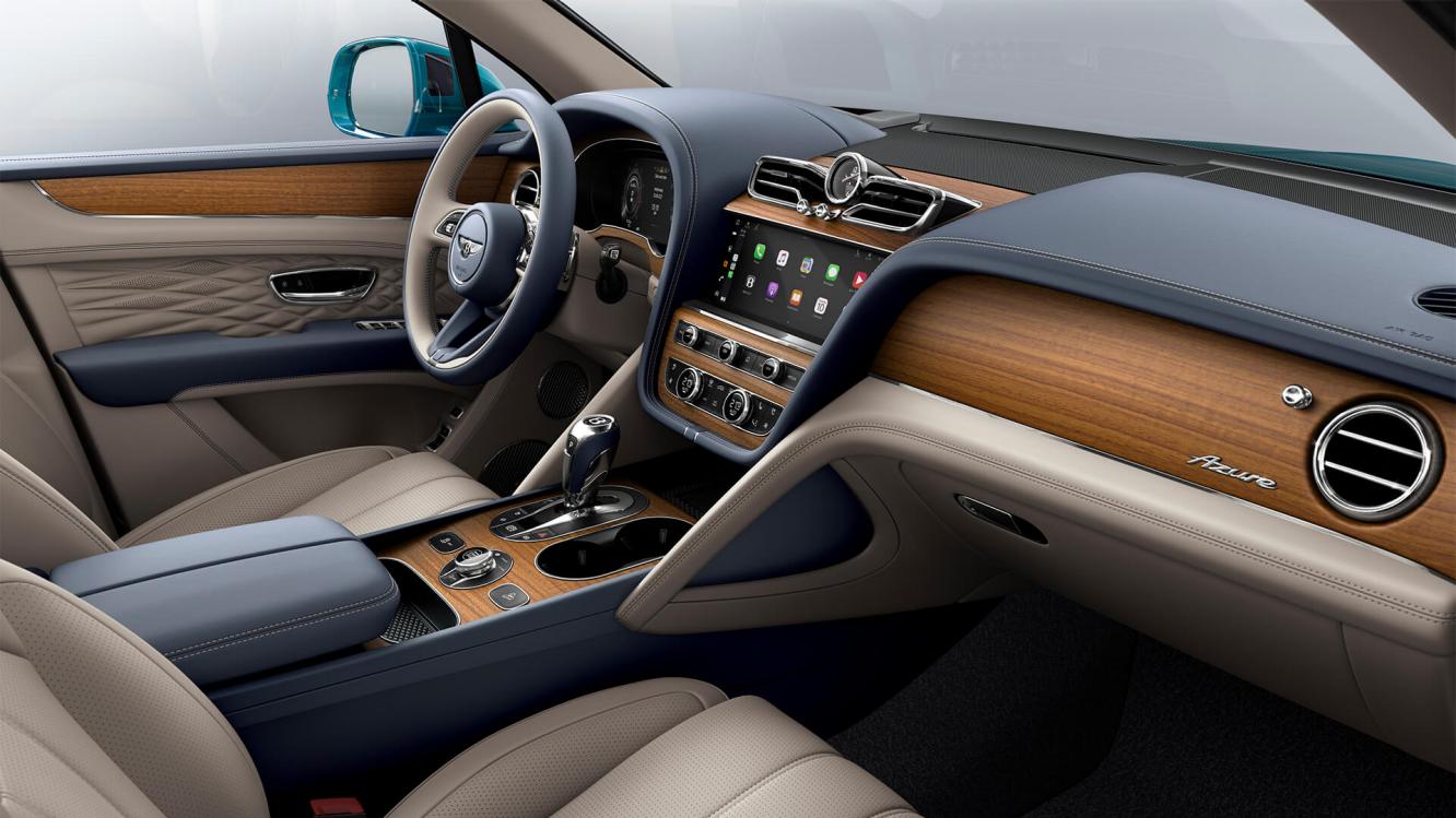 Bentley Bentayga EWB Azure interior with Open Pore Koa veneer and Portland hide seats, view from the passenger seat over looking the driver's seat. 