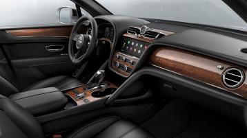 Bentley Bentayga EWB interior with a Crown Cut Walnut veneer, view from the passenger seat over looking the driver's seat.