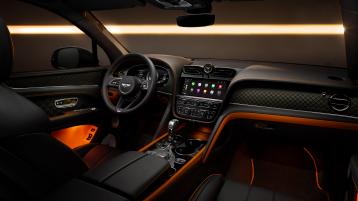 Interior front cabin view of Bentley Bentayga S, featuring Beluga leather and mandarin contrasting leather and Bentleys exclusive carbon weave on the dash fascia and in the door cards.
