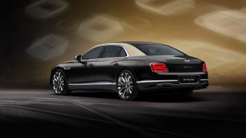 Rear three quarter of the new hybrid Bentley Flying Spur in Duo Tone exterior colours and Mulliner exclusive 22" directional wheels