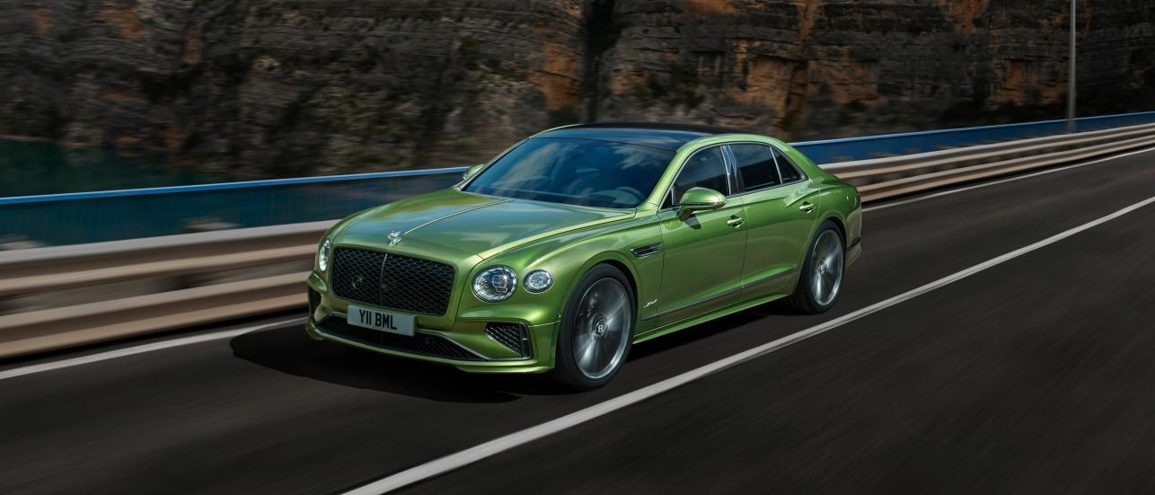 The new Hybrid Flying Spur Speed in Tourmaline Green with new directional Speed wheels driving on a bridge