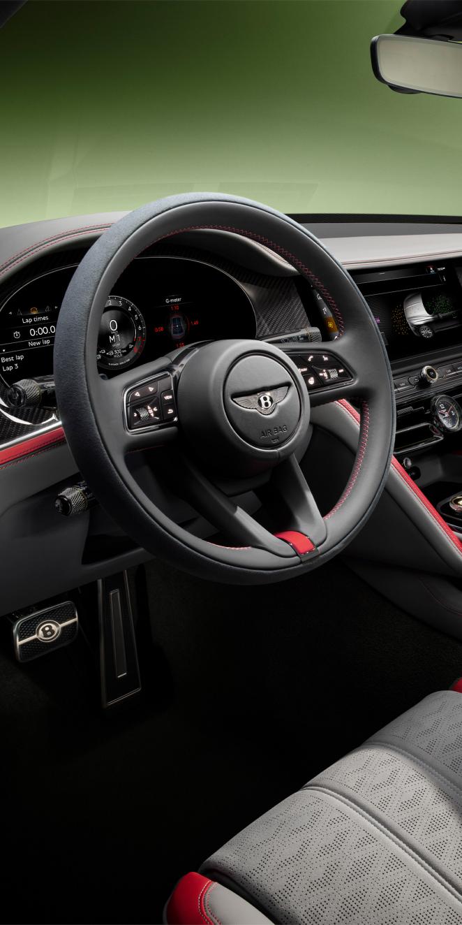 Driver side view of Bentley Flying Spur Speed with steering wheel in view featuring High Gloss Carbon Fibre veneer. 