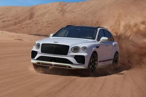 New Bentayga Speed in Snow Quartz by Mulliner exterior paint with the Bentayga Styling Specification and 23" Directional Wheels driving on sand dunes.