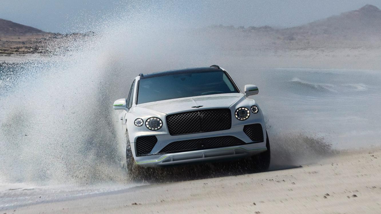 New Bentayga Speed in Snow Quartz by Mulliner exterior paint with the Bentayga Styling Specification driving through a coastal setting.