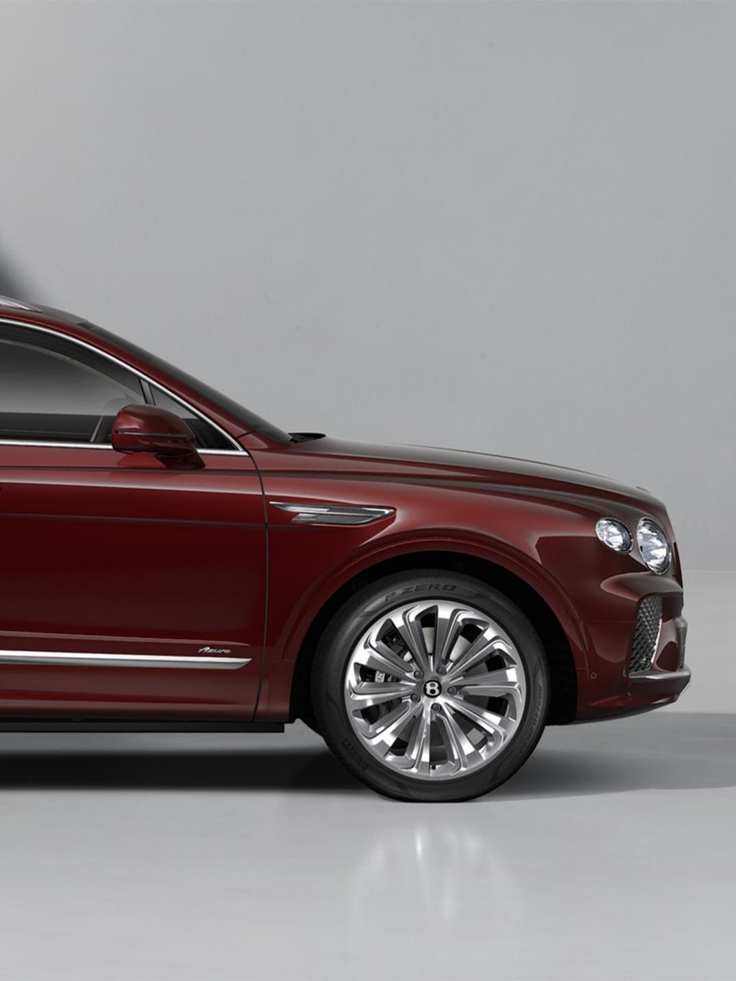 Bentayga EWB Azure SUV in Cricket Ball paint with 22" Ten Spoke Wheels front half side on 