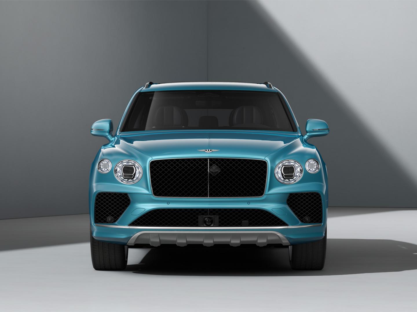 Side view of Bentley Bentayga EWB in Moonbeam colour driving through forest featuring Bentley ‘B’ wing vent.