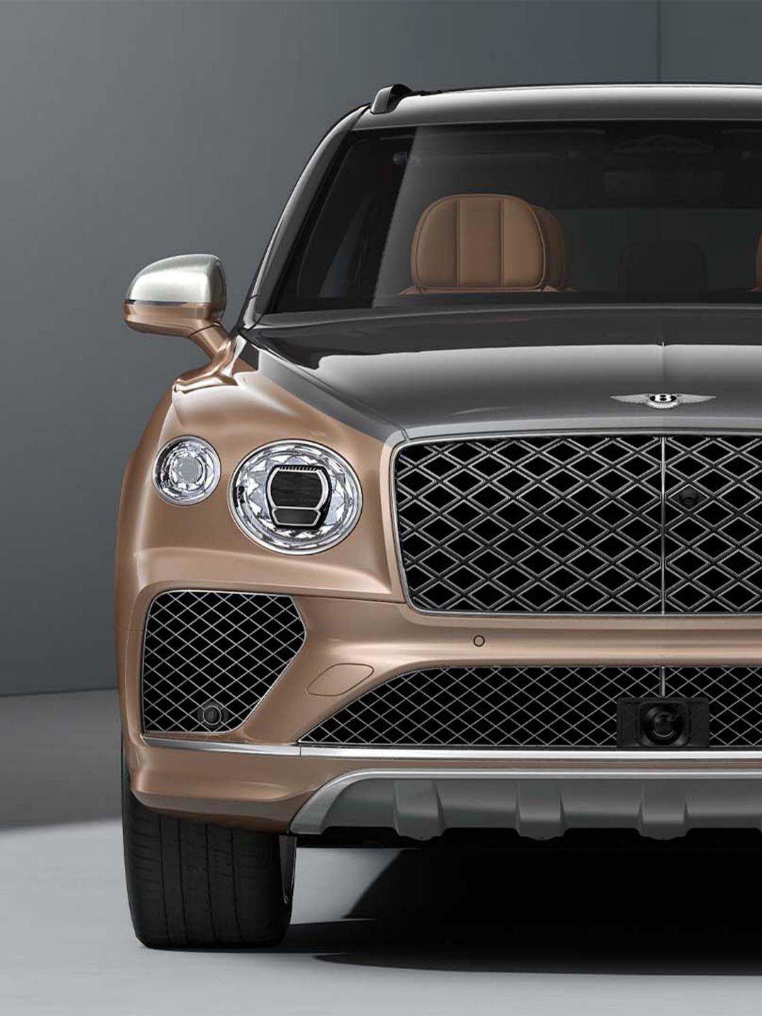 Bentley Bentayga EWB Mulliner SUV in dual tone Magnetic over Rose Gold paint with 22" Mulliner Wheels front half facing Mulliner diamond grille