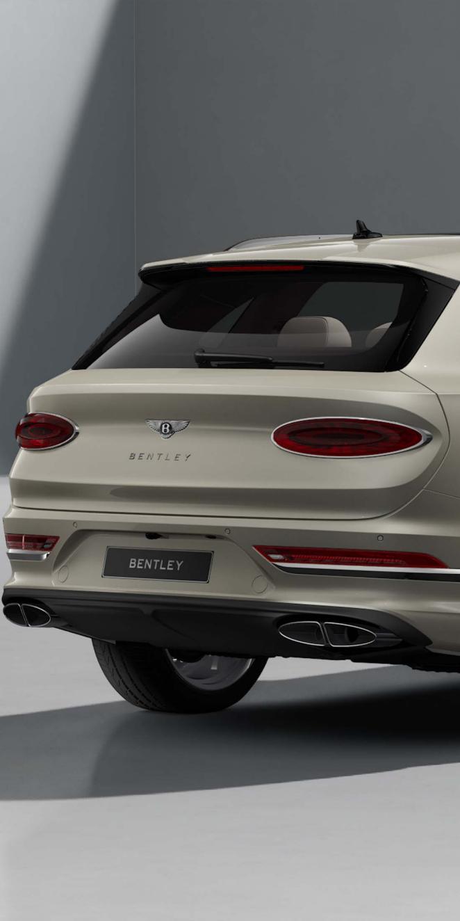 Rear view of Bentley Bentayga Azure in White Sand colour with black painted shark fin aerial and fixed rear spoiler.