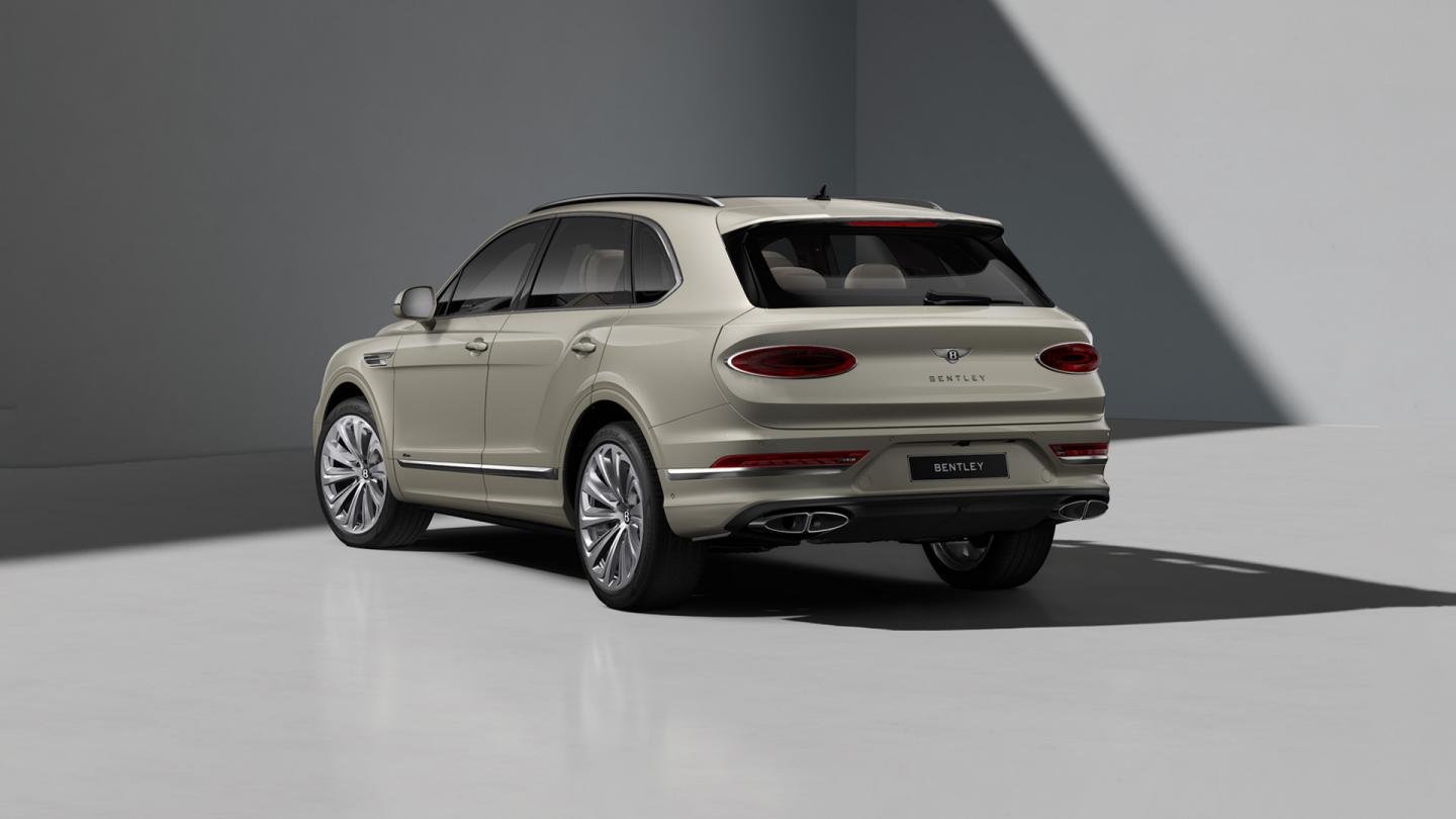 Rear three quarter of a Bentley Bentayga Azure in White Sand exterior paint and featuring 22" Ten Spoke Polished wheels