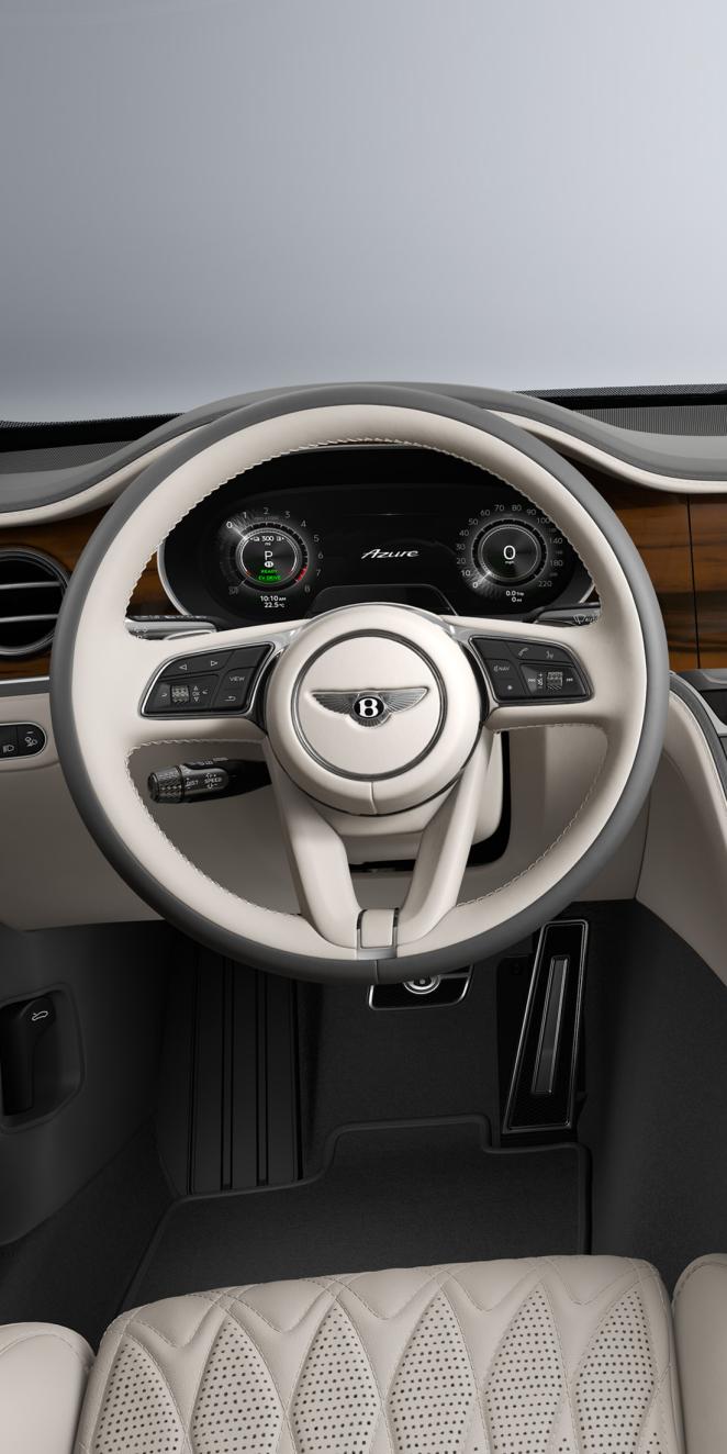 Driver’s view of the Bentley Flying Spur Azure steering wheel and Linen / Gravity Grey interior.
