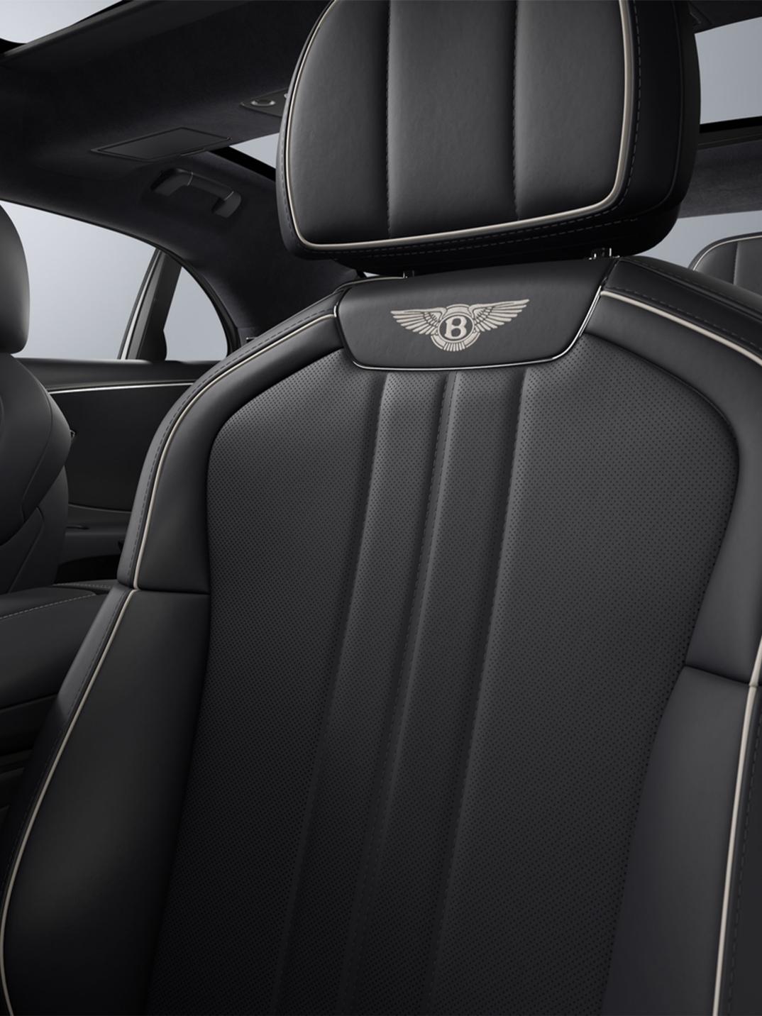 Rear passenger seat view inside the Bentley Flying Spur with Imperial Blue upholstery and Linen contrast stitching.