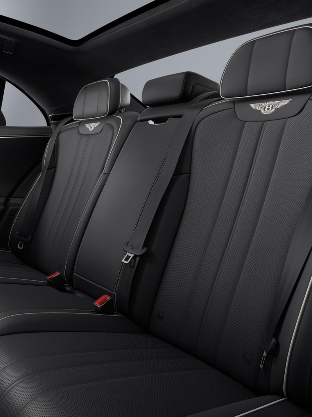 Rear passenger seat view inside the Bentley Flying Spur with Imperial Blue upholstery and Linen contrast stitching.