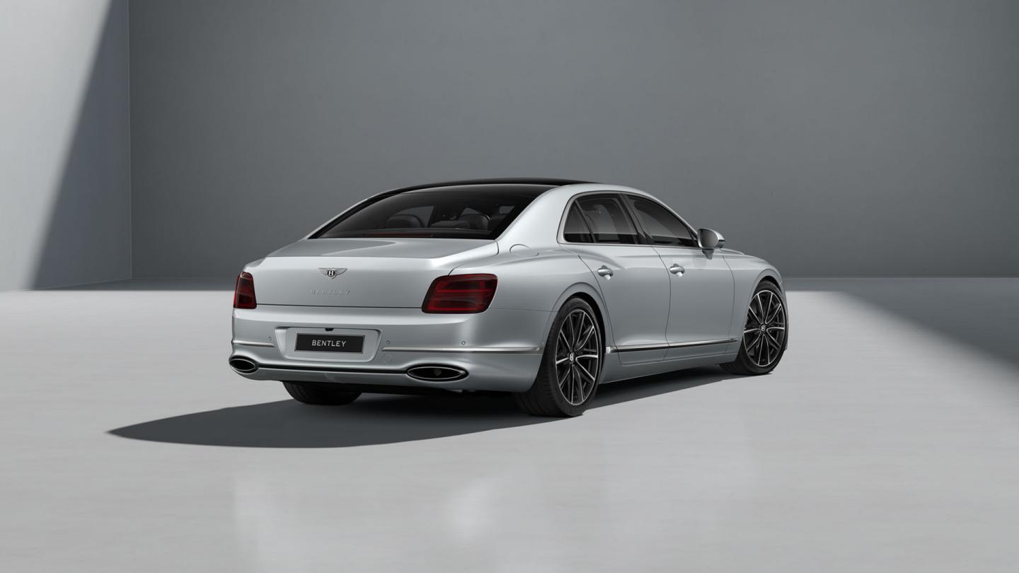 Rear three-quarter shot of the Bentley Flying Spur in Moonbeam with Bright Chrome Exterior detailing.
