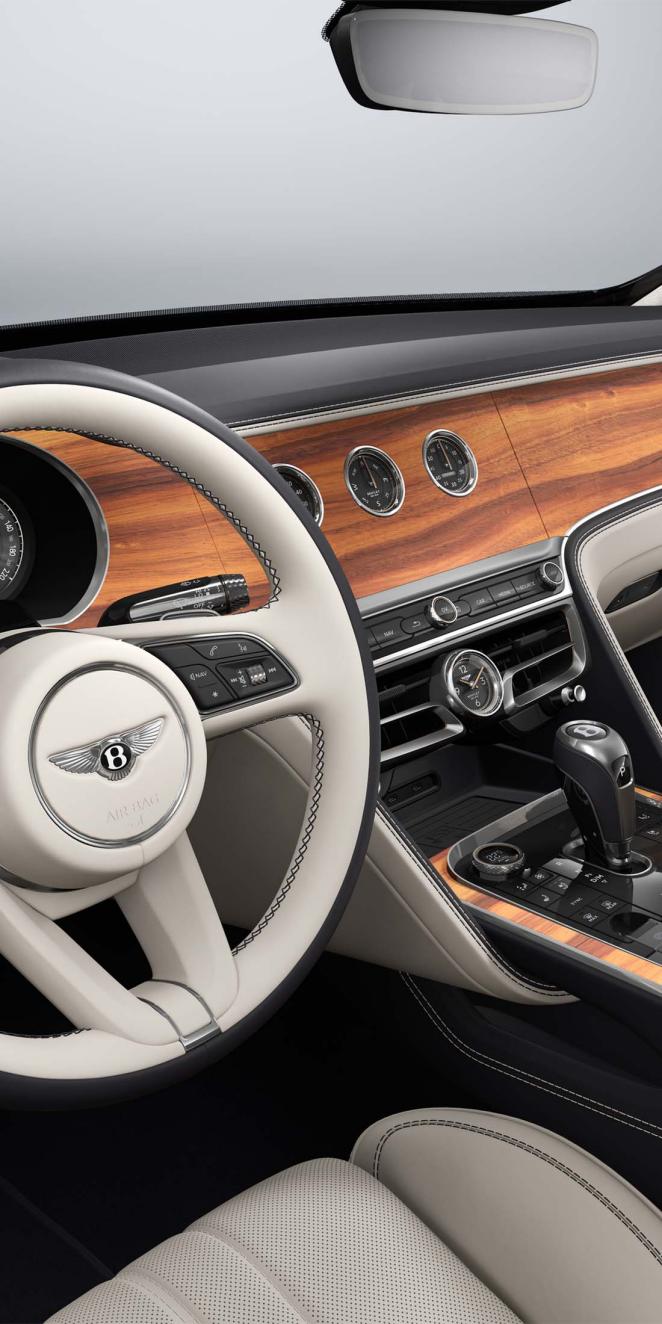 Side view of the Bentley Flying Spur steering wheel with Open Pore Koa veneer and rotating display visible.