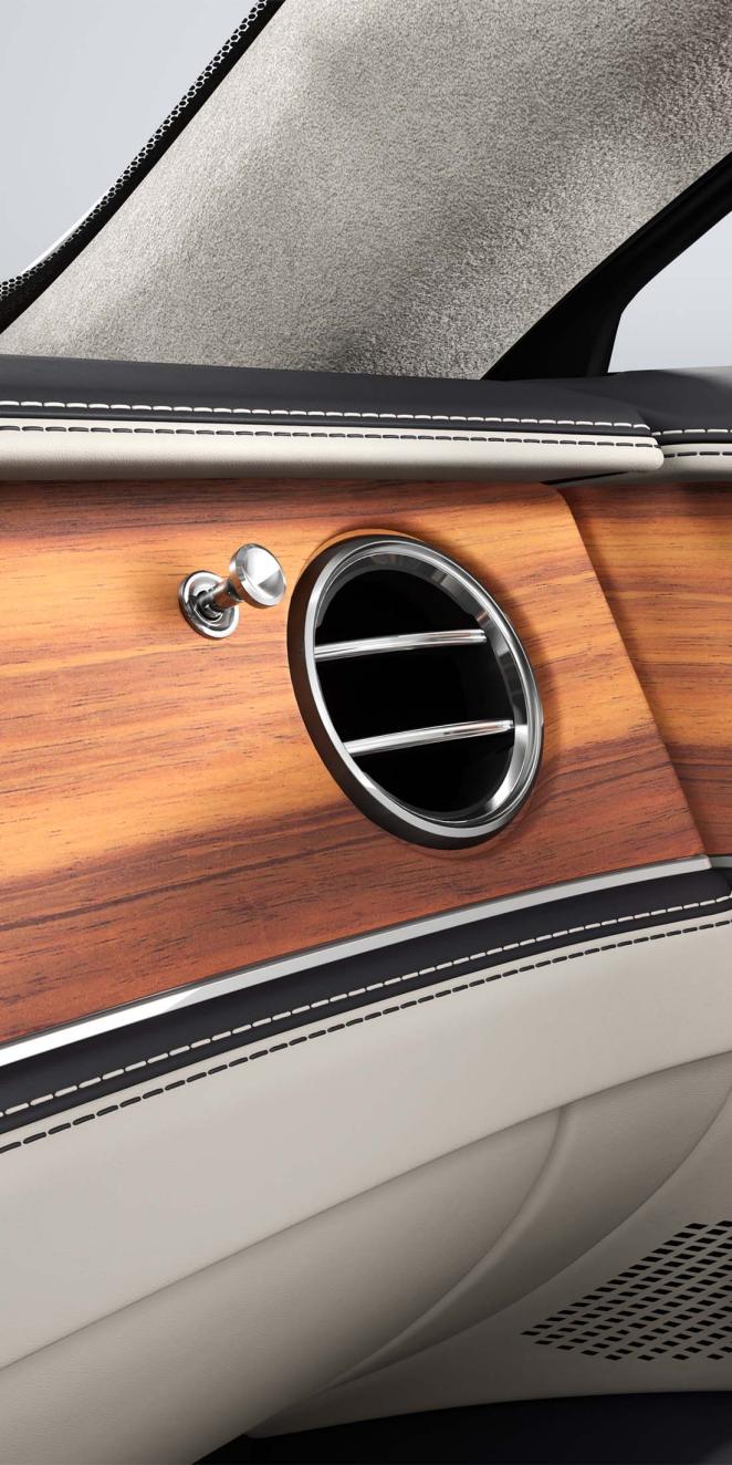 Close-up of the Open Pore Koa veneer and air conditioning vent inside the Bentley Flying Spur.