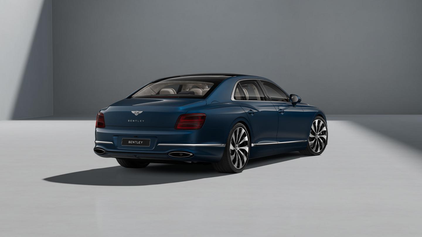 Rear three-quarter shot of the Bentley Flying Spur in Marlin with Bright Chrome Exterior detailing.