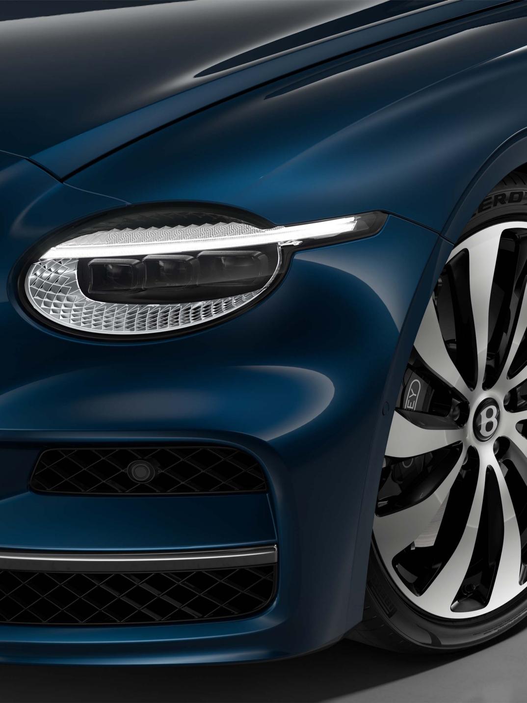 Front three-quarter close-up of the Bentley Flying Spur in Marlin showing the headlights and 22" Ten Spoke Wheel painted in black and bright machined.