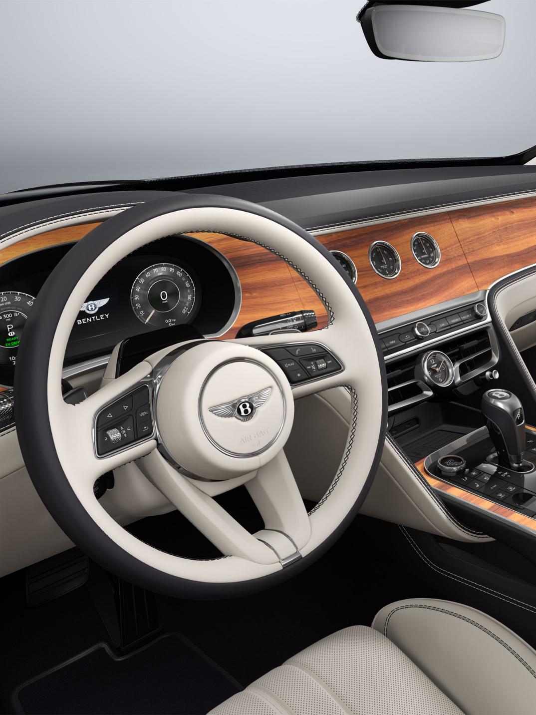 Side view of the Bentley Flying Spur steering wheel with Open Pore Koa veneer and rotating display visible.