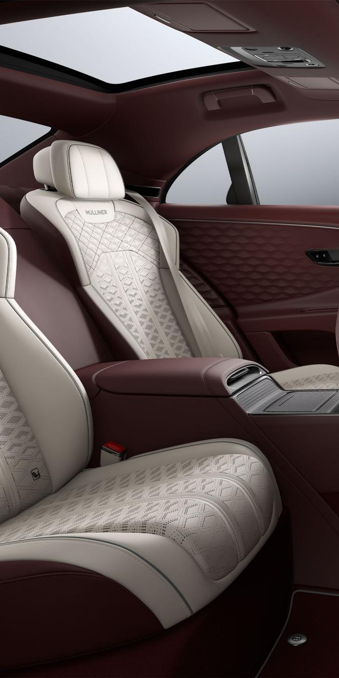 Rear passenger seat view inside the Bentley Flying Spur Mulliner with Linen, Cricket Ball and Stratos upholstery and 4 seat configuration.
