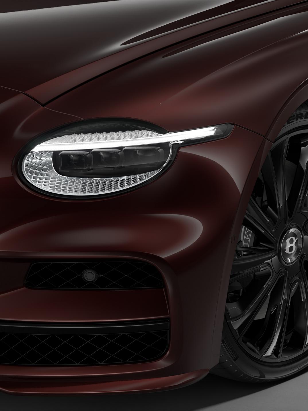 Front three-quarter close-up of the Bentley Flying Spur Mulliner in Cricket Ball showing the headlights and 22" Mulliner wheel painted in black.