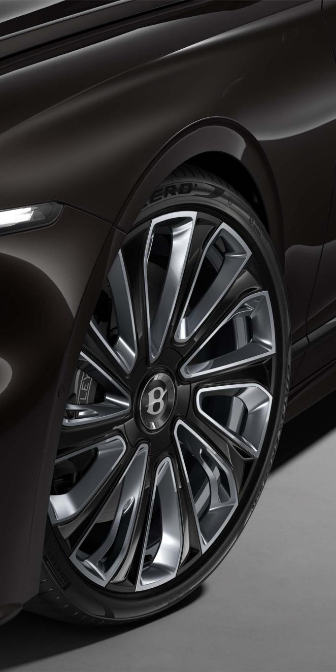 Innenansicht des Bentley Flying Spur Mulliner über ein beheizbares, zweifarbiges Drei-Speichen-Lenkrad in Lederverkleidung.