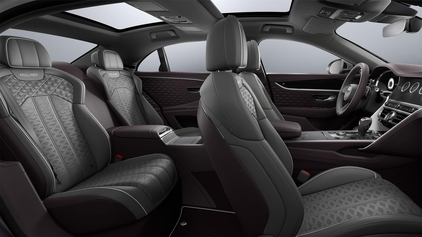 Side view from the rear passenger door into the Bentley Flying Spur Mulliner showing the Gravity Grey, Damson and White interior and 4 seat configuration.