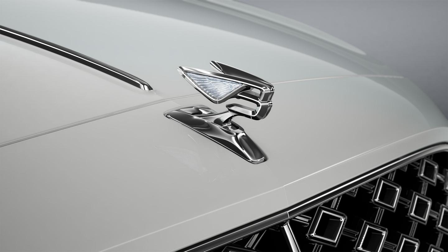 Close-up of the Flying B bonnet mascot on the Bentley Flying Spur Mulliner in Ice / Grey Violet.