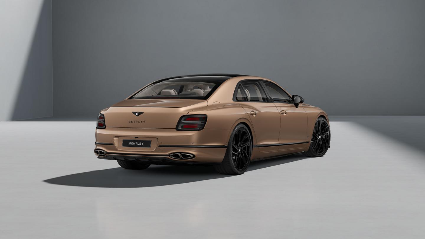 Rear three-quarter shot of the Bentley Flying Spur S in Rose Gold with Blackline Specification and Carbon Styling Spec.